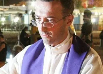 Don Vito Canto mentre impartisce la comunione