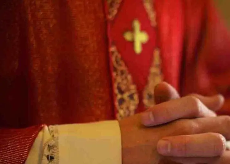 Sacerdote cattolico sullaltare in preghiera durante la messa