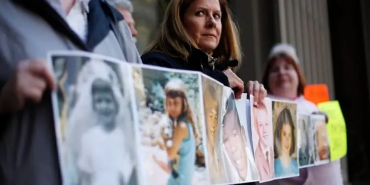 FILE - In this March 29, 2011, file photo, Barbara Blaine, President of Survivors Network of those Abused by Priests (SNAP), displays childhood photographs of adults who say they were sexually abused, during a news conference in Philadelphia. Barbara Blaine, the founder and former president of the Survivors Network of those Abused by Priests, has died. The organization known as SNAP announced on its Facebook page that Blaine died Sunday, Dept. 24, 2017, following a recent cardiac event. She was 61. (AP Phot