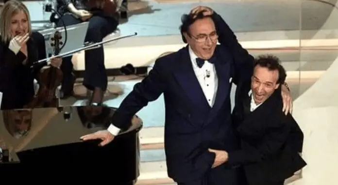 Enna, caso Rugolo, secondo la difesa… «Salutare toccando i genitali è pratica sdoganata» e in aula mostrano una foto di Baudo e Benigni