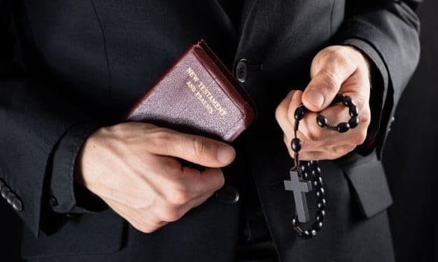 handen van een christelijke priester in het zwart gekleed met een kruisbeeld en een nieuwtestamentisch boek religieuze persoon met bijbel en gebedskralen ingehouden afbeelding 145134 240