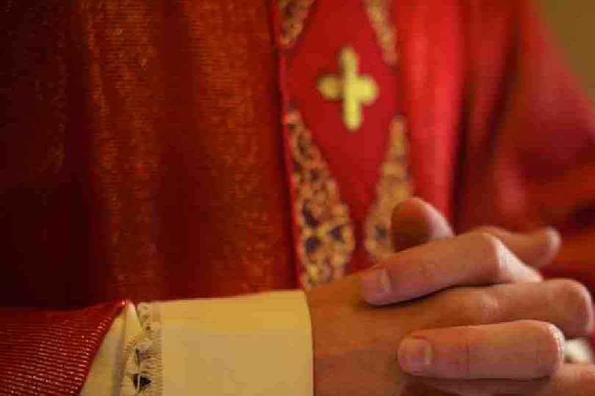 Sacerdote cattolico sullaltare in preghiera durante la messa